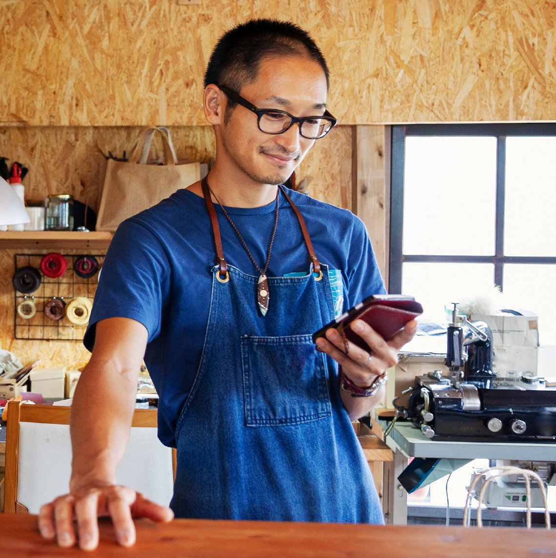 Hombre japonés-americano usando su telefono en su tienda